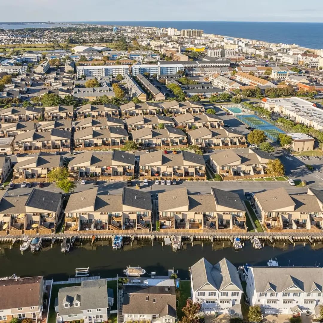Aerial view of a coastal neighborhood with condos and waterfront access.