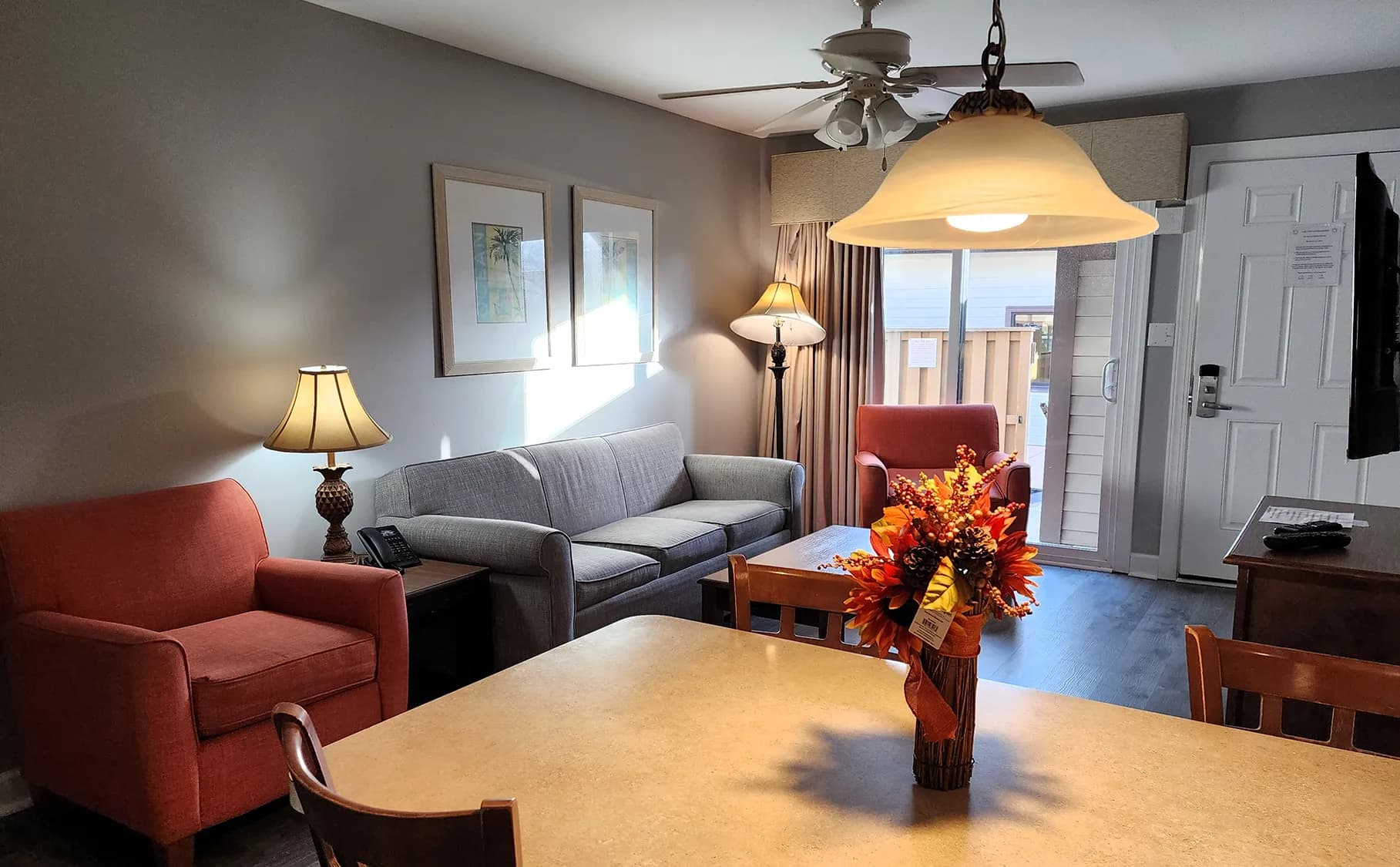 Cozy living area with comfortable seating, warm lighting, and a balcony view.