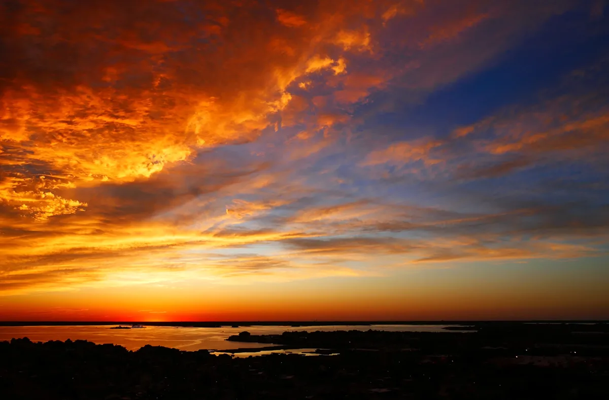Golden Ocean City sunset over sandy beach and waves.